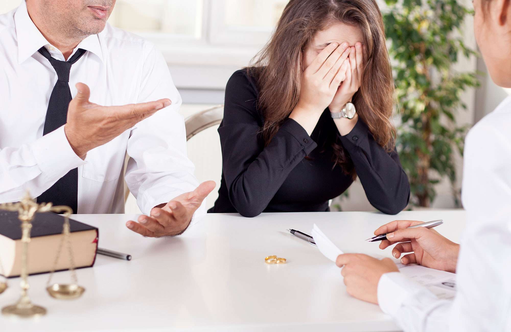 Woman with her hands on her face during a divorce meeting